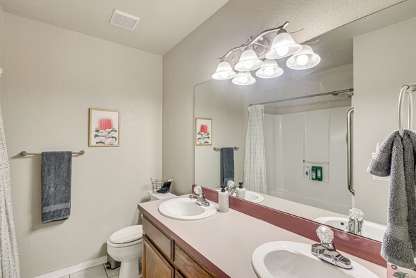 A bathroom with two sinks, a large mirror, and a shower. - 2 Mi to OU: Family-friendly Retreat w/ Patio! (Norman)