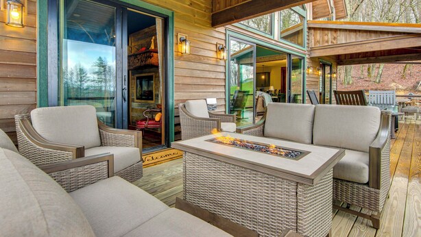 A cozy outdoor seating area with wicker furniture and a fire feature. - Scenic Sanctuary w/ Mtn Views: Glenville Lodge (Glenville)
