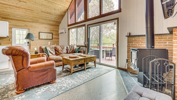 Ein gemütliches Wohnzimmer mit Ledersessel, Couchtisch aus Holz und Kamin.