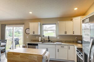 A modern kitchen with white cabinets, a granite countertop, a built-in oven, and a refrigerator.