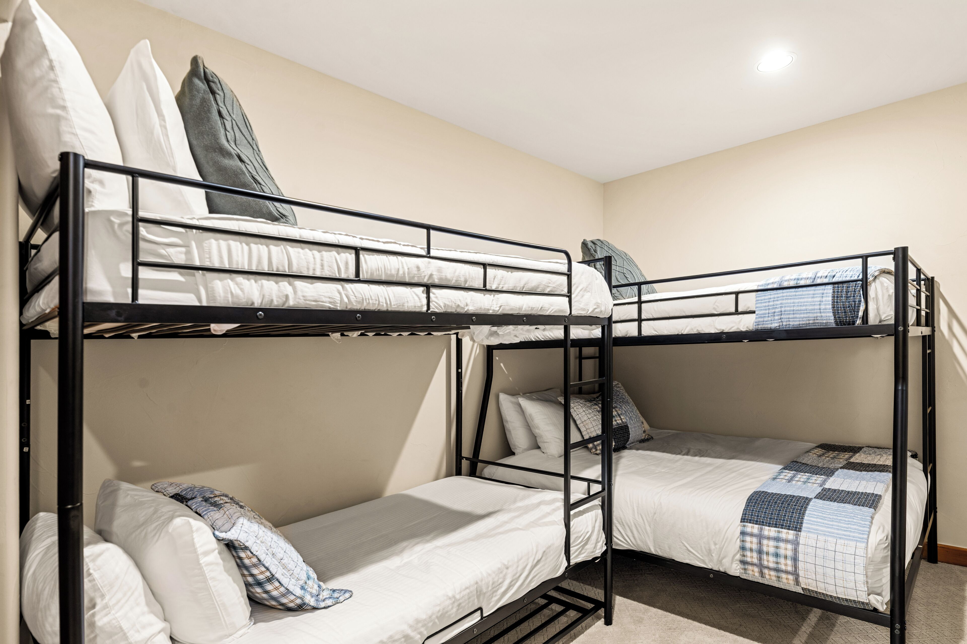 Een slaapkamer met stapelbedden en een eenvoudige indeling, met een raam en een deur.