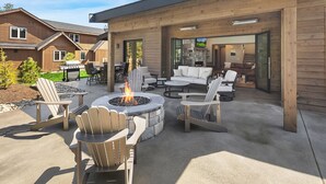 Un patio al aire libre con sillas Adirondack, un hogar de piedra y una chimenea de piedra.