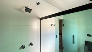 A modern bathroom with a glass shower enclosure, a handheld showerhead, and a wall-mounted faucet. - Hotel Estrela Carapicuiba (Carapicuiba)