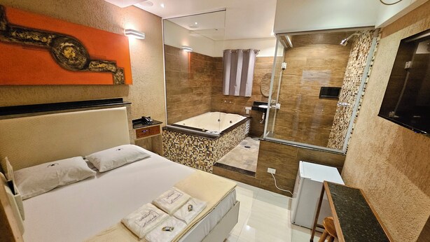 A modern hotel room with a bed, a desk, a shower, and a bathroom. - Hotel Estrela Carapicuiba (Carapicuiba)