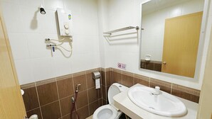 Un baño con inodoro, lavamanos y secamanos.