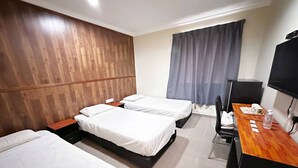 Habitación de hotel con dos camas individuales, cabecero de madera, escritorio con silla, televisión de pantalla plana y ventana con cortinas.