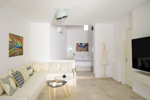 Relax in this stylish space with a sofa, flat-screen TV, and unique wireframe lamp.