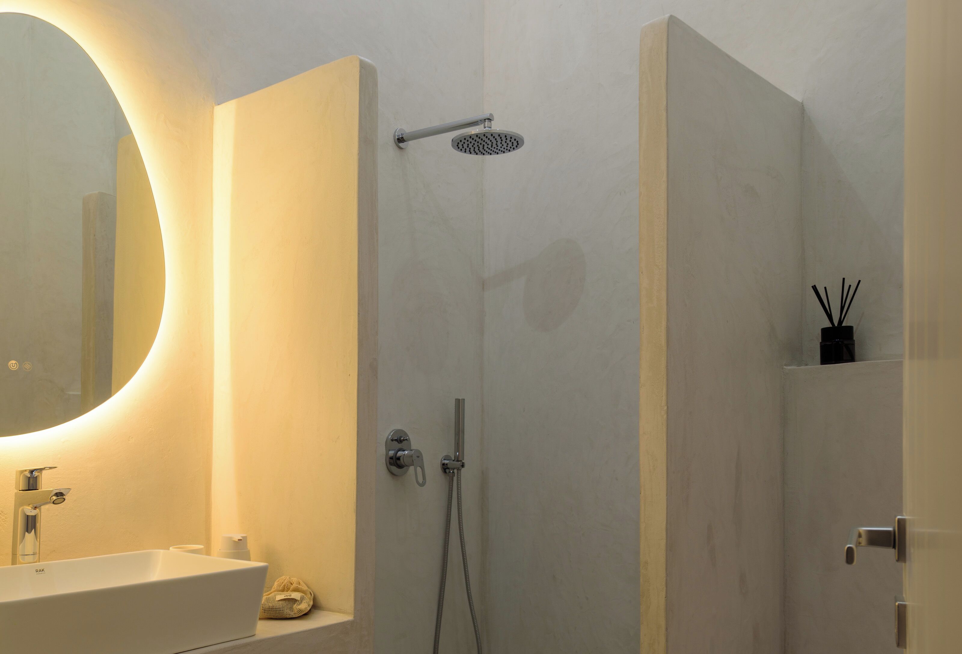 Ein modernes Badezimmer mit großem Spiegel, Waschbecken, Dusche und Toilette.