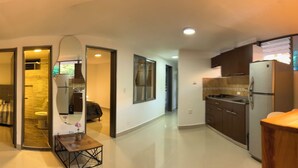 A modern living room with a flat-screen TV, a wooden entertainment unit, and a seating area. - 3-bedroom apartment in cool Envigado with WiFi (envigado)