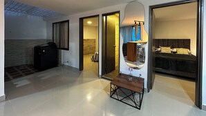 A hotel room with a bed, a small table with a lamp, and a bathroom visible through an open door. - 3-bedroom apartment in cool Envigado with WiFi (envigado)