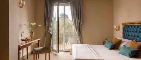 A hotel room with a bed, a desk, a chair, and a view of the outdoors.