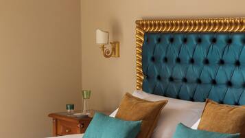 Hotelkamer met een groot bed, nachtkastje, wandlamp en decoratief wandpaneel.