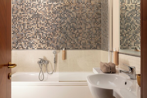 A bathroom with a bathtub, a sink, and a shower.