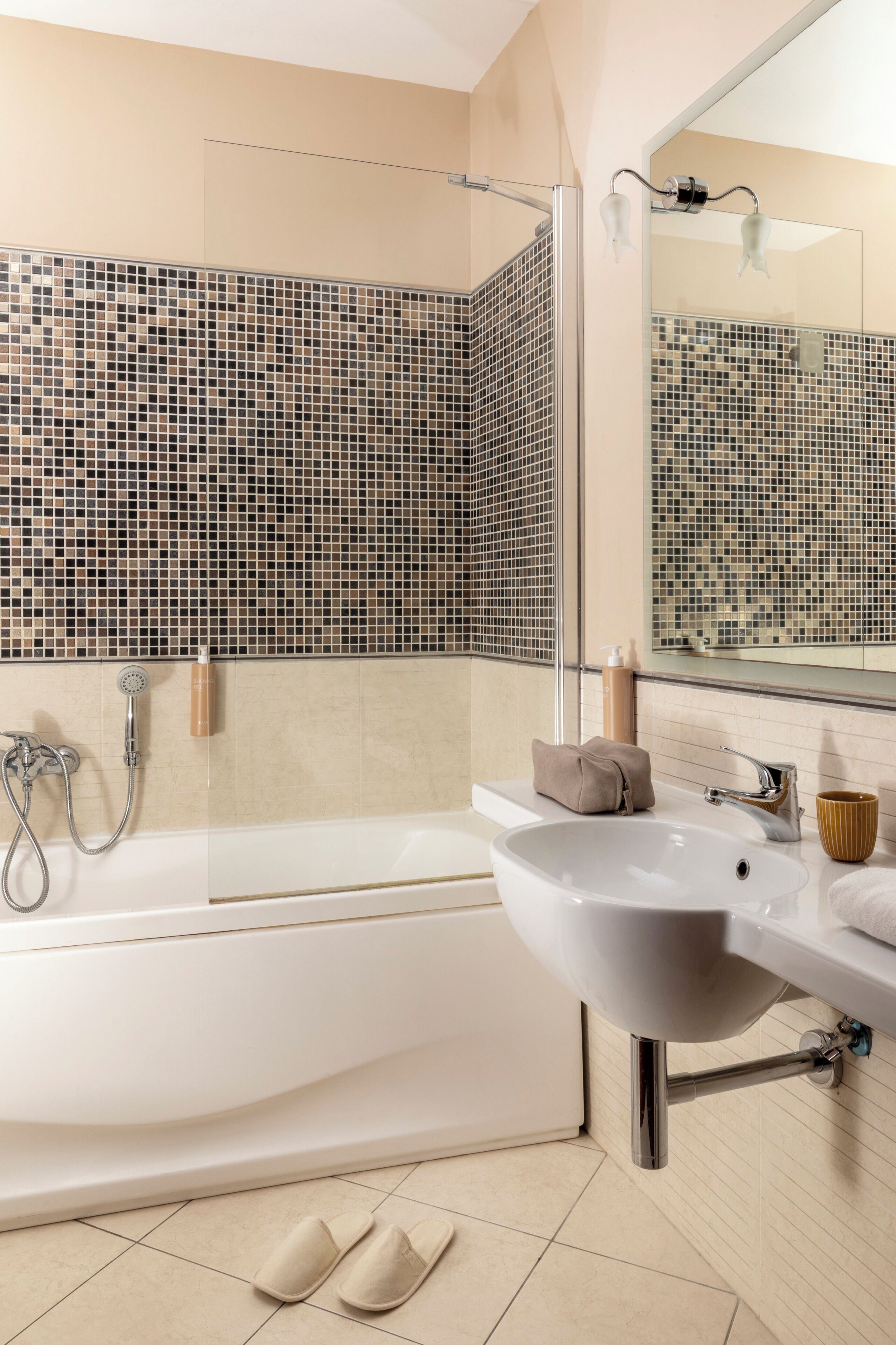 A modern bathroom with a bathtub, a sink, a shower, and a mirror.