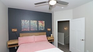 A bedroom with a bed, a ceiling fan, and a nightstand with a lamp. - Modern Ascend 2 Bedroom Townhouse (Grand Junction)