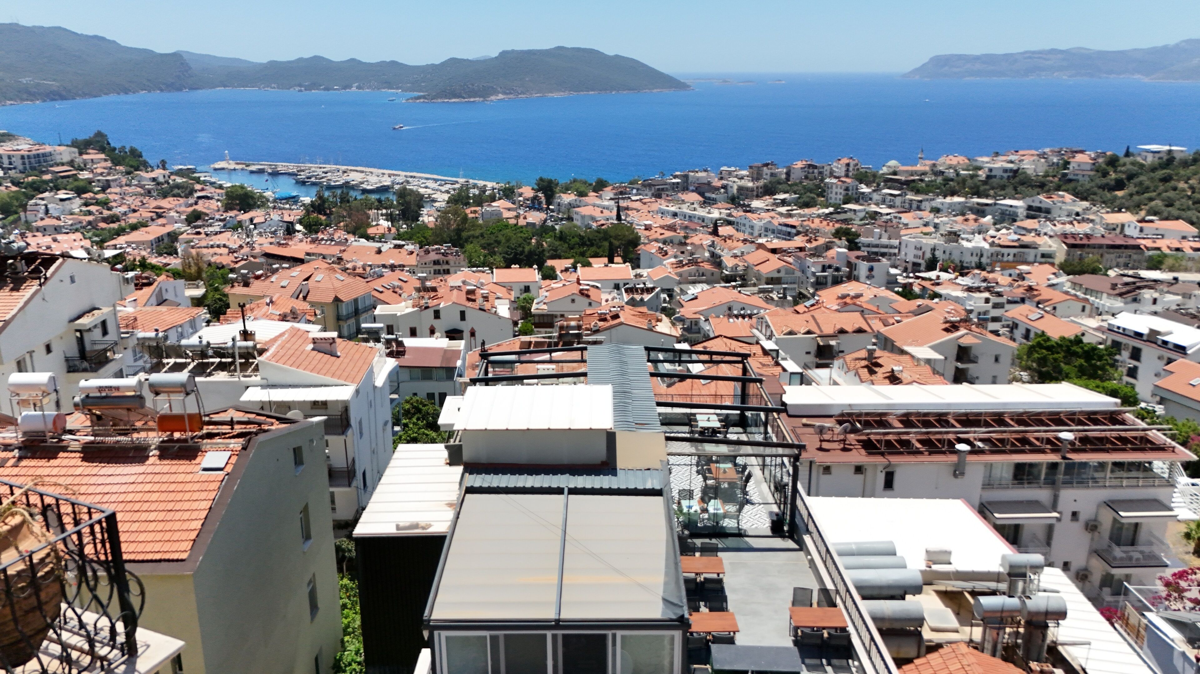 A coastal town with a view of the sea and mountains in the distance.