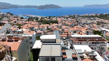 A coastal town with a view of the sea and mountains in the distance.