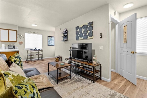 A living room with a sofa, coffee table, TV, and a dining area with a table and chairs. - Perfect Private Central Coast Getaway in Salinas! (Salinas)