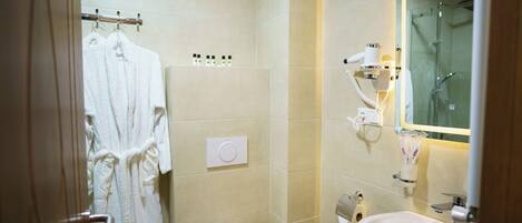 Un baño con inodoro, lavabo, espejo y toallero.