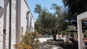 Un pati amb mobiliari exterior, una pérgola i una jardineria de pedra.