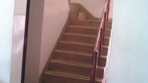 Un escalier en bois avec une rampe, menant à l’étage supérieur.