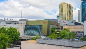 A modern hotel with a prominent 'Westfield' sign, surrounded by other buildings and trees. - Prime Location 1BD Apartment in Chatswood (Chatswood)
