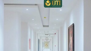 A long, narrow hotel corridor with white walls and a ceiling with recessed lighting. - OTI Hotel Benin  (Benin City)
