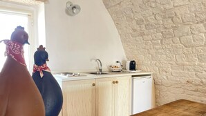 Une cuisine avec des meubles de rangement en bois, un évier, une cuisinière et une machine à café.