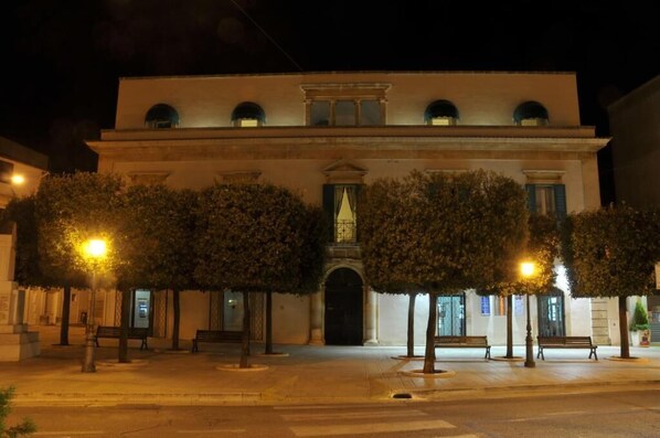 Un edificio histórico con fachada simétrica, ventanas de arco y una entrada central.