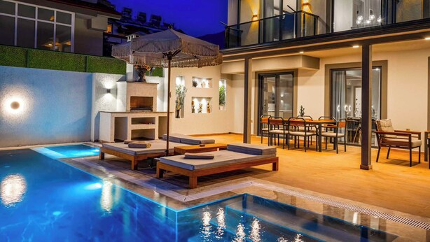Un área de piscina moderna al aire libre con sillas de descanso y zona de comedor.