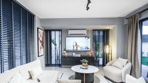 Una sala de estar moderna con un sofá, una mesa de centro y un televisor.