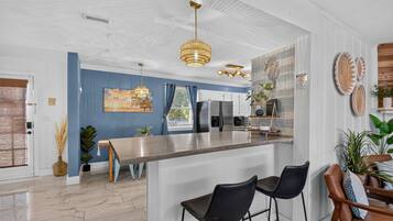 Una cocina moderna con barra, electrodomésticos de acero inoxidable y una pared azul.