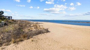 A sandy beach with a wooden fence and a house in the background. - Coastal home w/ pool, hot tub & fire pit (Norfolk)