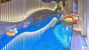 Ein Pool mit modernem Design, ein weißer Zaun und ein Haus im Hintergrund.