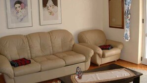 A living room with two beige sofas, a coffee table, and two framed pictures on the wall. - Apartman Žardin with AC and balcony (Punat)