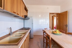 Réfrigérateur, un four, surface de cuisson, vaisselle et ustensiles