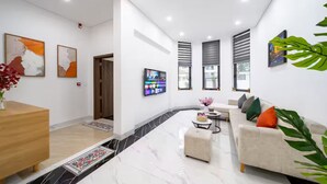 Una sala de estar moderna con un sofá, una mesa de centro y un televisor montado en la pared.