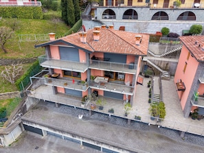 Un edificio de varios pisos con balcones, una terraza y fachada de piedra.
