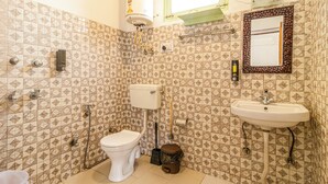 Een badkamer met toilet, wastafel en douche.