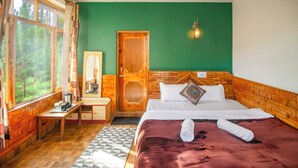 Een kamer met een bed, een houten bureau, een spiegel en een raam met gordijnen.
