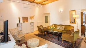 A living room with a sofa, chairs, a coffee table, and a television. - Dimora Mattonaia: Cozy apartment with AC and WiFi (Firenze)
