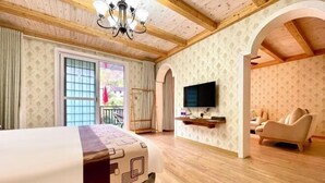 A hotel room with a bed, a television, a sofa, and a balcony with a view. - Hangzhou Lin'an Daming Spring Inn (Daming Mountain) (Hangzhou)