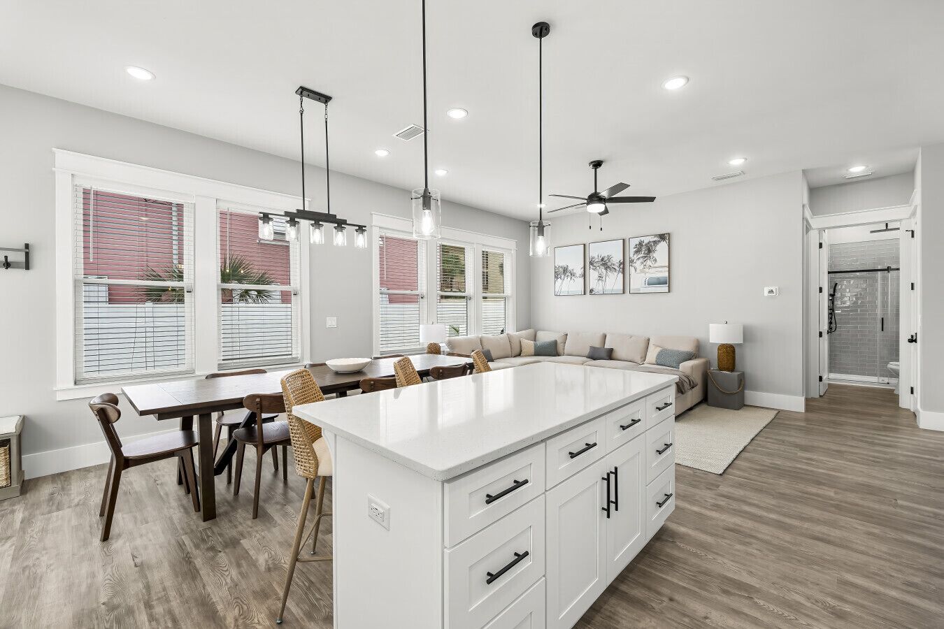 A modern kitchen with a large island, dining area with chairs, and a built-in seating area.