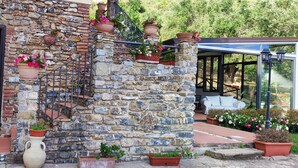 A stone building with a wooden door, a staircase with railings, and potted plants. - AGRITURISMO  LA FOCAZZA (Ascea)
