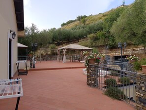 A patio area with outdoor seating, a pergola, and stone walls. - AGRITURISMO  LA FOCAZZA (Ascea)