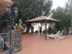 An outdoor patio with a pergola, stone pillars, and potted plants. - AGRITURISMO  LA FOCAZZA (Ascea)