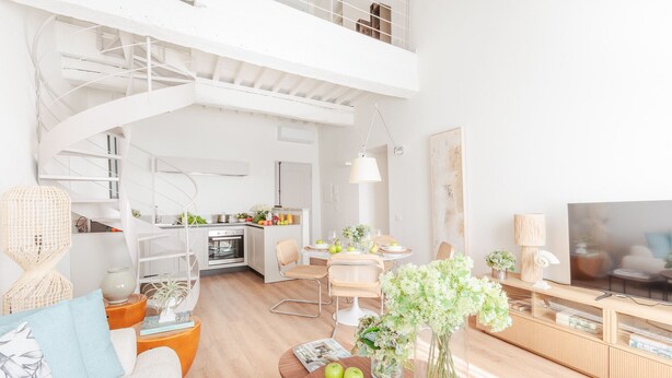 A modern living space with a staircase, dining area, kitchen, and a TV. - Letizia Vista in Lucca (Lucca)