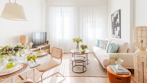 A modern living room with a dining area, a sofa, a TV, and a large window with sheer curtains. - Letizia Vista in Lucca (Lucca)