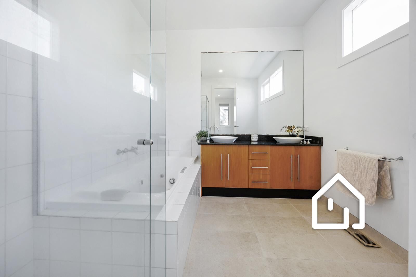 A modern bathroom with a glass shower enclosure, a bathtub, and a vanity with a sink and mirror.