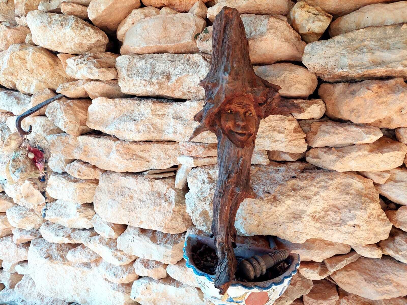 Un mur de pierre orné d’une sculpture en bois.
